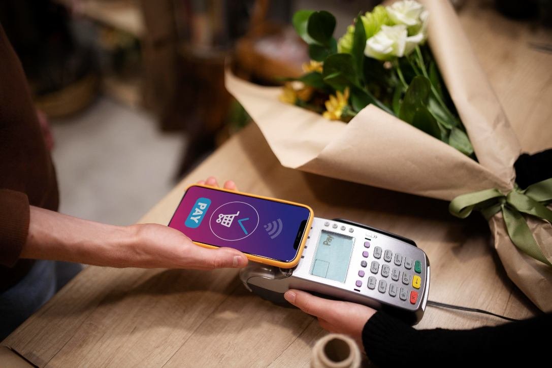 A mobile in hand paying payment through payment gateway machine